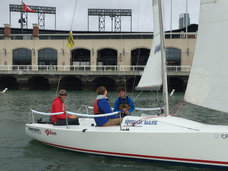 Three sailors aboard an Andrews 21 in front of the ballpark