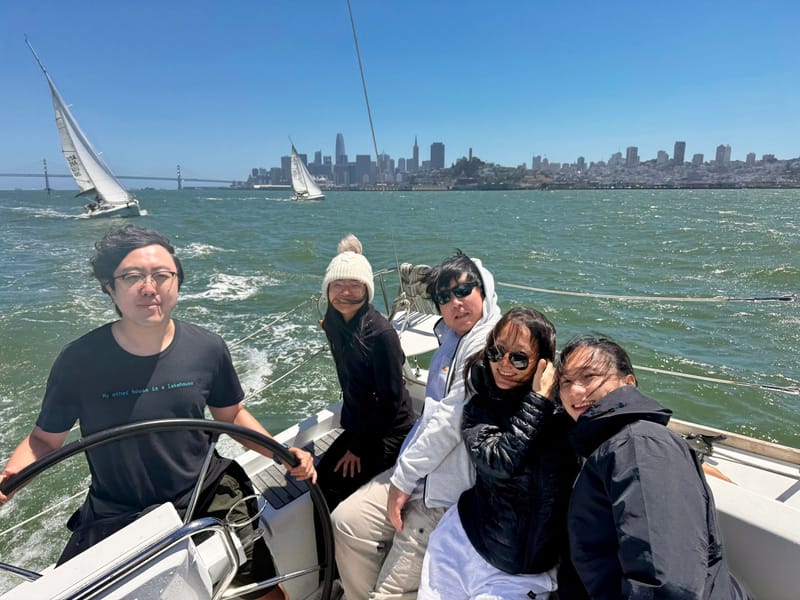 A group aboard Valkyrie with the San Francisco skyline behind