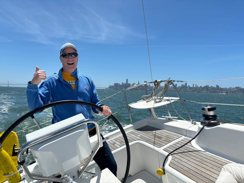 A sailor at the helm of a J/105, giving a thumbs up