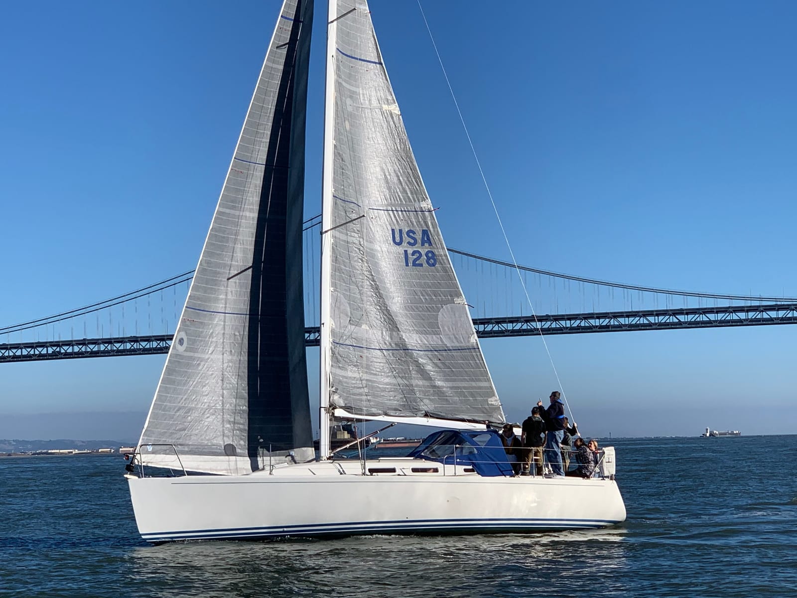 The J/109 Cirrus sailing beneath the Bay Bridge
