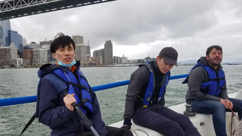 A J/80 crew in life jackets near the Bay Bridge